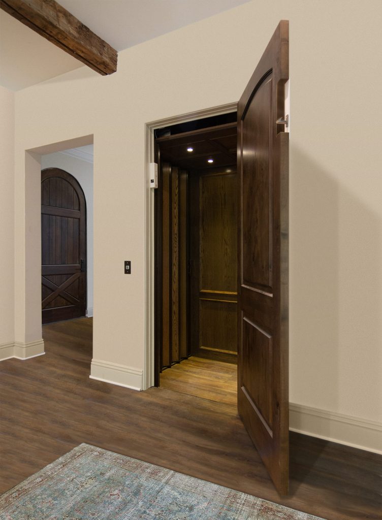 Southeast Elevator Plantation series elevator with adjacent openings and wood veneer accordion gates